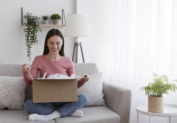 Satisfied smiling woman looking into open parcel box — Stockfoto