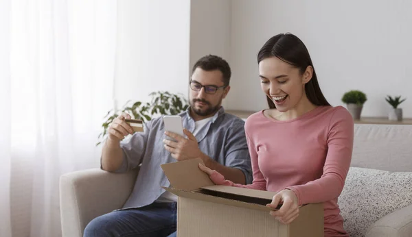 Happy young couple unboxing package together at home — Stock Fotó