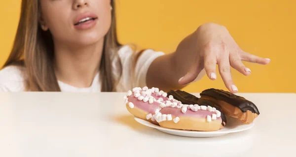Sugar Addiction. Unrecognizable Woman Taking Eclairs From Plate, Enjoying Junk Food — Stock Fotó