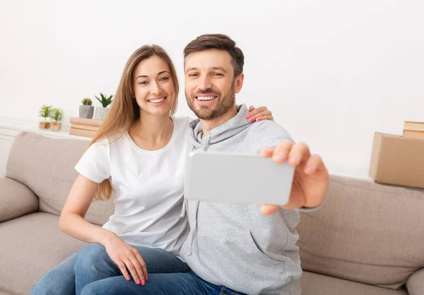 Happy couple making selfie while sitting on sofa — Φωτογραφία Αρχείου