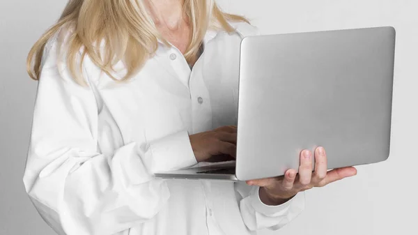 Primer plano de mujer de negocios madura sosteniendo el ordenador portátil en el estudio —  Fotos de Stock