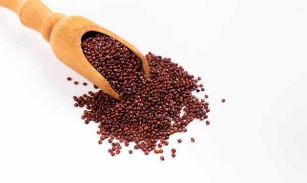 Senza glutine. La quinoa rossa si disperde dal cucchiaio di legno — Foto Stock