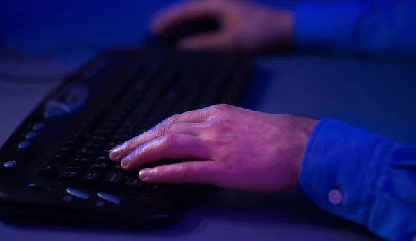 Mãos masculinas no teclado do computador, jogando jogo online em casa — Fotografia de Stock
