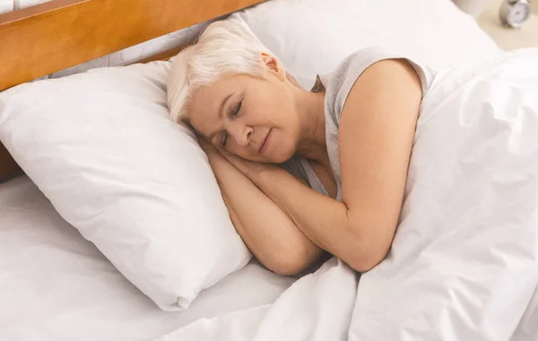 Señora mayor durmiendo en la cama por la mañana, panorama — Foto de Stock