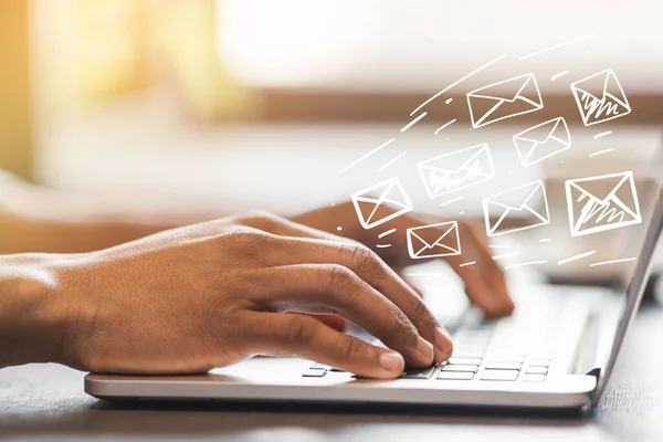 Online communication. African American man typing and sending e-mails in office, design with envelope icons — Stockfoto