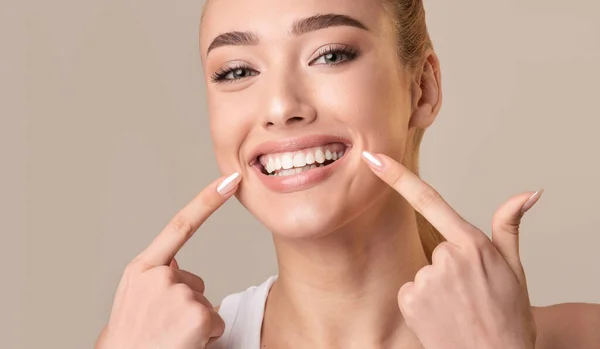 Young Woman Touching Mouth Smiling To Camera On Beige Background — Φωτογραφία Αρχείου