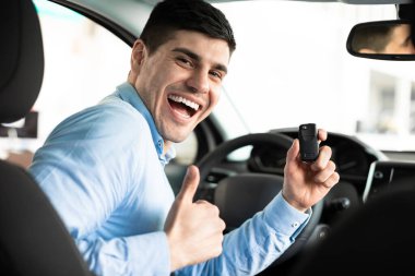 Man Showing Car Key And Thumb Up Sitting In Auto