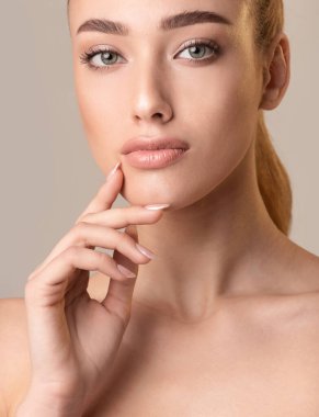 Pretty Girl Posing Touching Face Over Beige Background