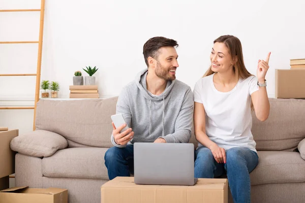 Young couple sitting in a new apartment and use laptop — Stock Fotó