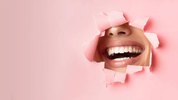 Unrecognizable Woman Smiling Through Hole In Pink Paper, Panorama — Zdjęcie stockowe