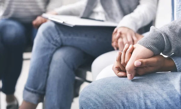 Group of addicted people holding hands supporting each other in rehab — Stockfoto