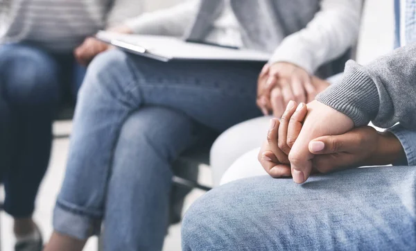 Grupo de adictos tomados de la mano apoyándose mutuamente en rehabilitación — Foto de Stock