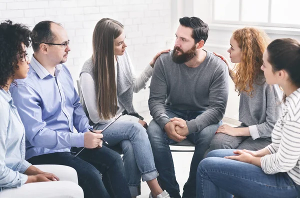 Therapy Group Members Comforting Upset Man On Community Meeting In Rehab — Zdjęcie stockowe