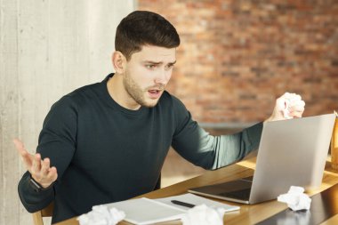Emotional Worker Looking At Laptop Having Problem Sitting In Office