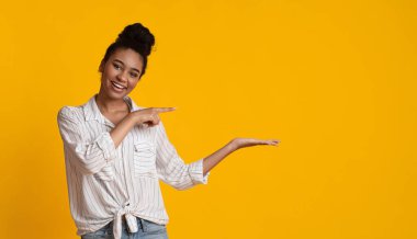 Cheerful Black Girl Pointing At Something On Her Open Palm
