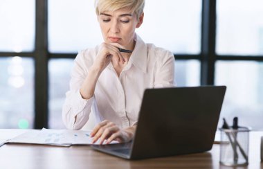 Woman At Laptop Reading Business Report Sitting In Office