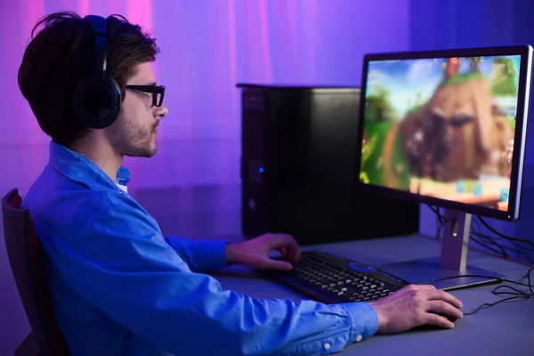 Gamer Playing Games Sitting At PC At Home At Night — Stockfoto
