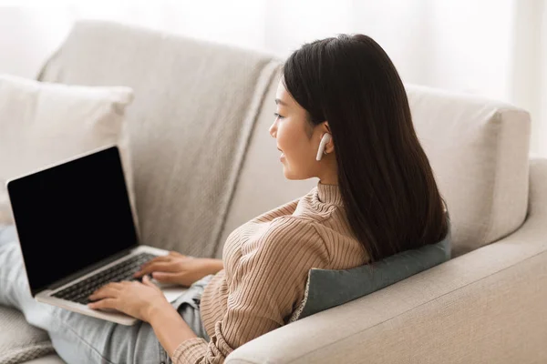 Asiática chica estudiando en línea, escuchando música en airpods —  Fotos de Stock