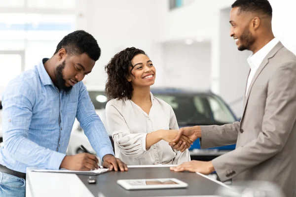 Couple Shaking Hands With Salesman In Cars Selling Center — Stock Fotó