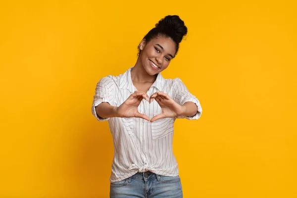 Positive Romantic Afro Girl Shaping Hands Like Heart On Yellow Background — Stok fotoğraf