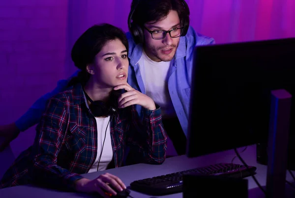 Millennial casal jogando jogos de computador sentados juntos em casa — Fotografia de Stock