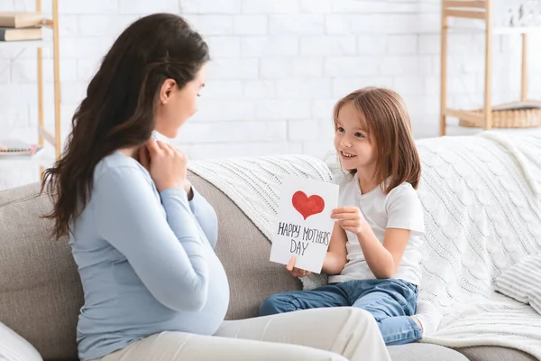 Surprised pregnant woman and her little daughter celebrating Mothers Day — Stok fotoğraf