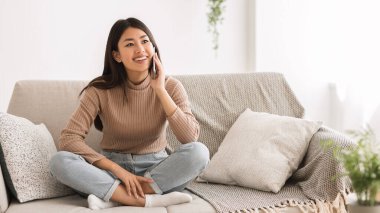 Cheerful girl talking on phone with friend