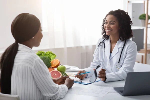 Alegre dietólogo que muestra al paciente cómo usar la aplicación móvil —  Fotos de Stock