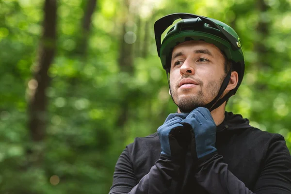 Handsome man putting his helmet on before cycling — Zdjęcie stockowe