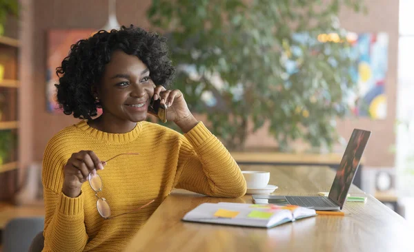 Весела чорна жінка розмовляє з діловими партнерами по телефону — стокове фото