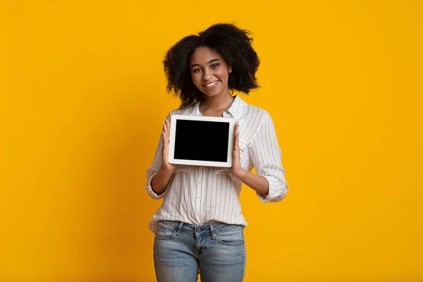 Alegre chica negra mostrando tableta digital con pantalla negra, imagen burlona — Foto de Stock