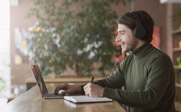 Cara positivo estudando língua estrangeira on-line, sentado no café — Fotografia de Stock