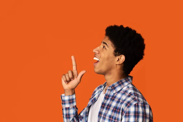 Encontrar inspiración. Joven hombre afroamericano que tiene una nueva idea sobre el fondo de color, vista lateral. Copiar espacio — Foto de Stock