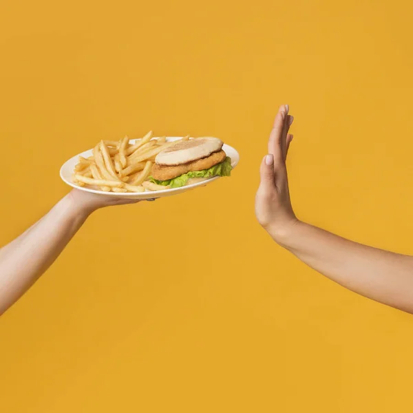 Hand Showing Stop Gesture To Offered Plate With Junk Food — Zdjęcie stockowe