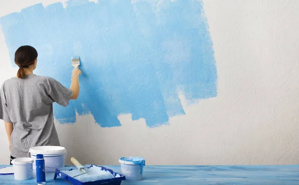 Chica pone la primera capa de pintura azul — Foto de Stock