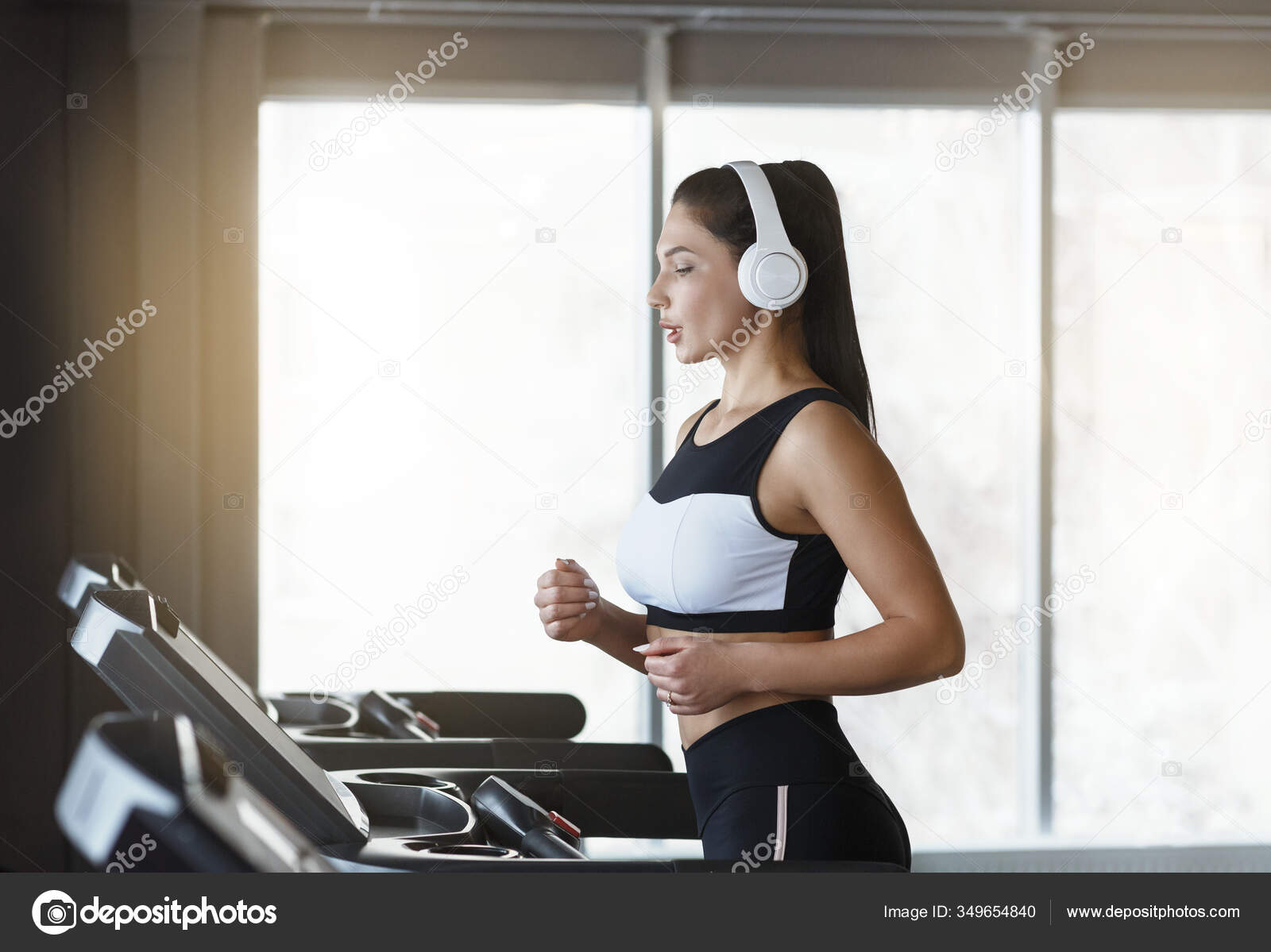 Doing sport. Young active fit woman with long legs listening to music and  doing sport Stock Photo - Alamy