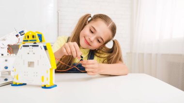 Robotics concept. Little technician working with wires on electronic toy