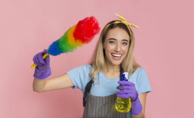 Smiling girl holds colorful duster brush and threatens with spray clipart