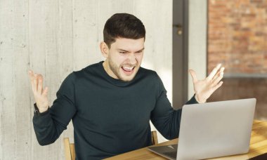 Angry Office Worker Shouting Sitting At Laptop At Workplace Indoor
