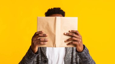 Young african student pretended as if he was reading a book