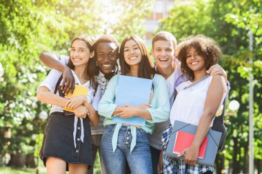 Portrait of happy multicultural students posing at camera outdoors