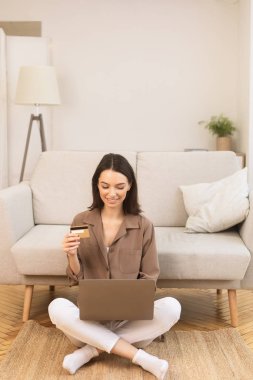 Girl making purchases sitting on the carpet