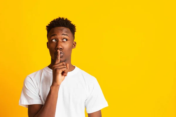 African man making silence gesture putting finger on his lips — Stockfoto