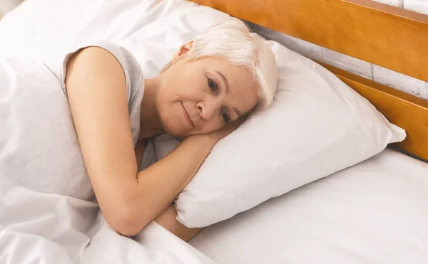 Upset senior woman thinking about life in bed, free space — Stock Photo, Image