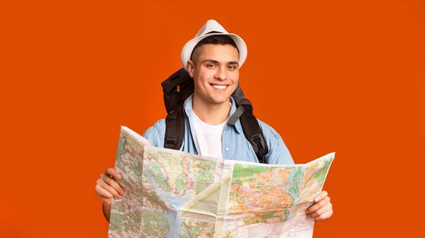 Joyful hiker with big backpack holding map — ストック写真