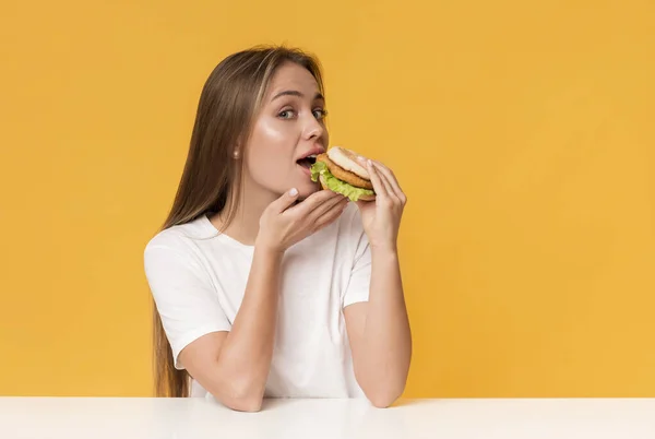 Refeição de fraude. Mulher com fome comendo fast food, mordendo hambúrguer — Fotografia de Stock