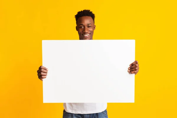 Excited african american man holding blank poster — Stock fotografie