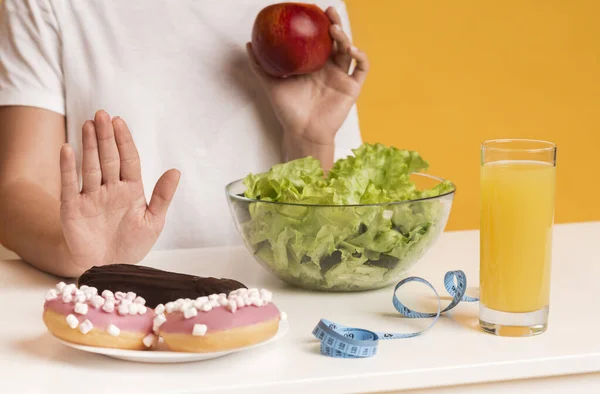 Mulher irreconhecível rejeitando junk food e escolhendo maçã e salada — Fotografia de Stock