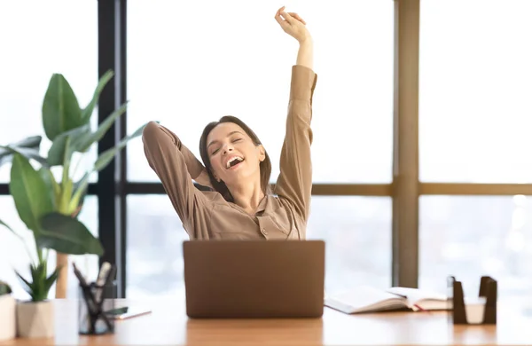 Happy european manager stretching body at work — Stockfoto