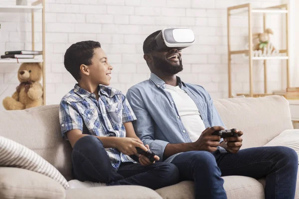 Preteen africano chico y su papá tratando de VR establecer en casa — Foto de Stock